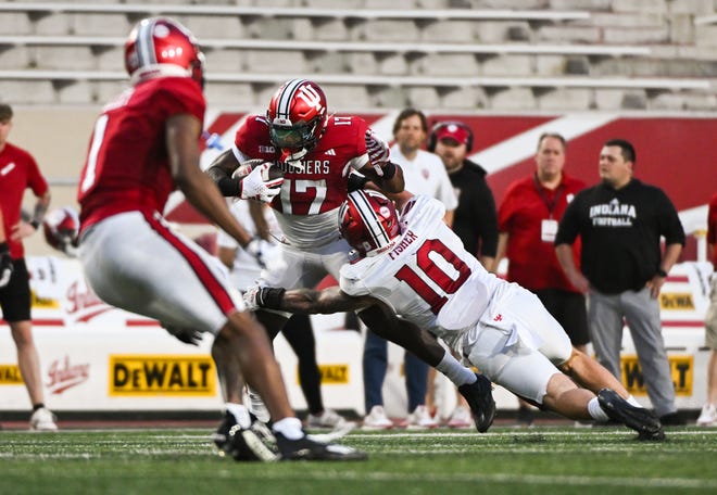 Indiana Hoosiers running back Ty Son Lawton (17) runs after a catch as Indiana Hoosiers linebacker Aiden Fisher (10) defends during the Indiana football spring game at Memorial Stadium on Thursday, April 18, 2024.