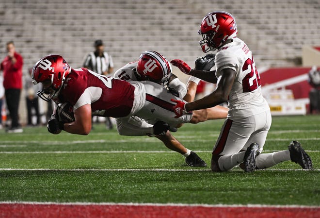 Indiana Hoosiers tight end Zach Horton (44) runs after a catch against Indiana Hoosiers defensive back Terry Jones Jr (12) during the Indiana football spring game at Memorial Stadium on Thursday, April 18, 2024.