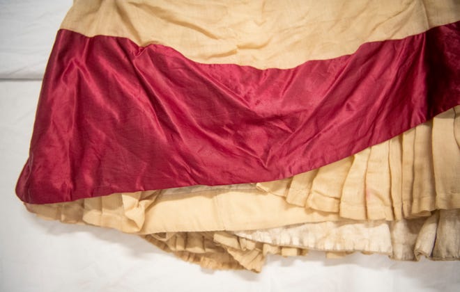 A crimson swath adorns the bottom of the Ida Kenney's graduation dress, which was donated to Indiana University's Elizabeth Sage Historic Costume Collection in the 1980s. Kenney graduated from IU in 1879.