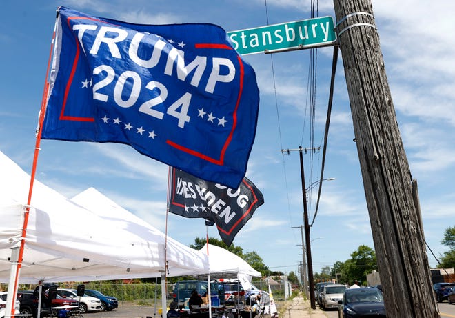 Various flags, hats and other items are for sale at tents a block away from the 180 Church before a roundtable discussion with former President Donald Trump inside the 180 Church in Detroit on Saturday, June 15, 2024.