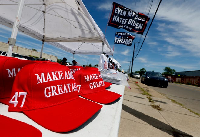 Various flags, hats and other items are for sale at tents a block away from the 180 Church before a roundtable discussion with former President Donald Trump inside the 180 Church in Detroit on Saturday, June 15, 2024.