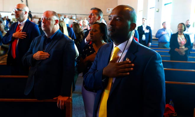 Dorian Thompson of Plymouth joins others in the Pledge of Allegiance before a roundtable discussion with former President Donald Trump inside the 180 Church in Detroit on Saturday, June 15, 2024.