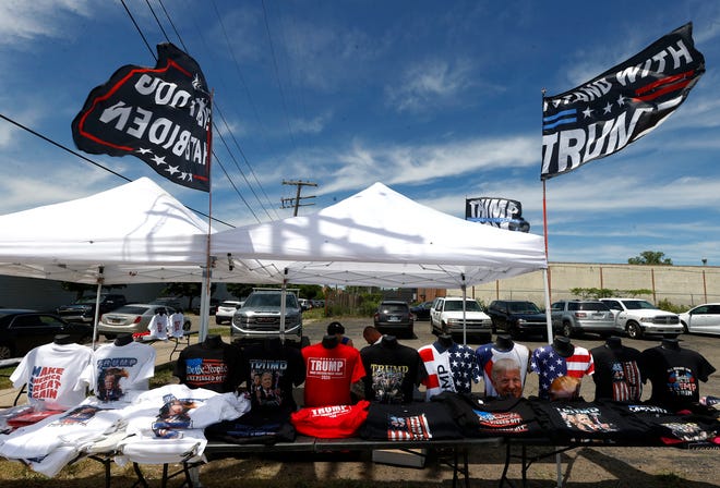 Various flags, hats and other items are for sale at tents a block away from the 180 Church before a roundtable discussion with former President Donald Trump inside the 180 Church in Detroit on Saturday, June 15, 2024.