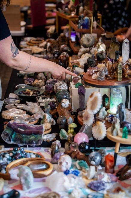 A customer looks over the items at The Art of the Green Witch booth during the Midsommar Market at the Monroe County Convention Center on Saturday, July 13, 2024. The event was put on by The Burnished Raven.