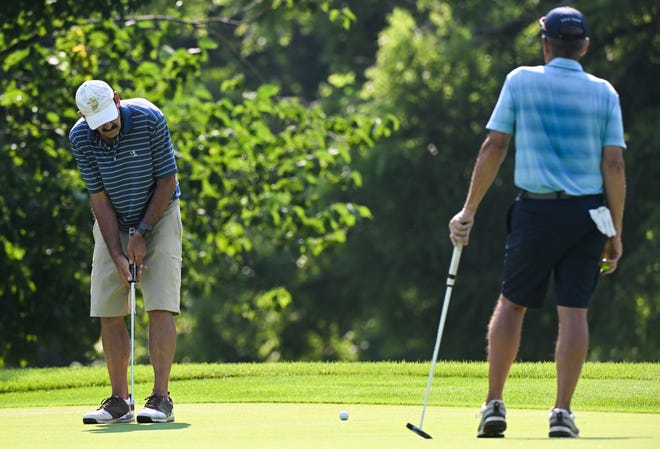 Rory Brown hits a putt as Dan Neubecker watches during the finals in the Super Senior Championship division of the City Golf Tournament at Cascades Golf Course on Sunday, July 14, 2024.