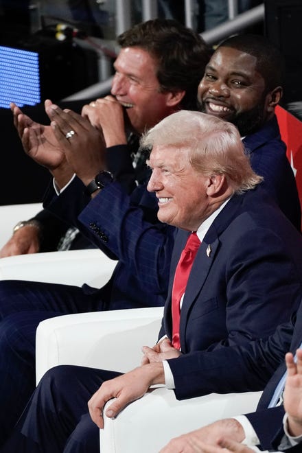 Former President Donald Trump laughs with Tucker Carlson and Rep. Byron Donalds during the first day of the Republican National Convention. The RNC kicked off the first day of the convention with the roll call vote of the states on July 15, 2024, in Milwaukee, Wis.