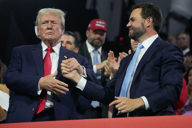 Former President Donald Trump shakes hands with Republican vice president nominee JD Vance during the first day of the Republican National Convention on July 15, 2024, in Milwaukee, Wis. The RNC kicked off the first day of the convention with the roll call vote of the states.