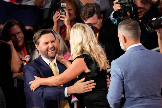 Vice Presidential nominee JD Vance greets Marjorie Taylor Greene in the family box during the second day of the Republican National Convention at the Fiserv Forum. The second day of the RNC focused on crime and border policies.