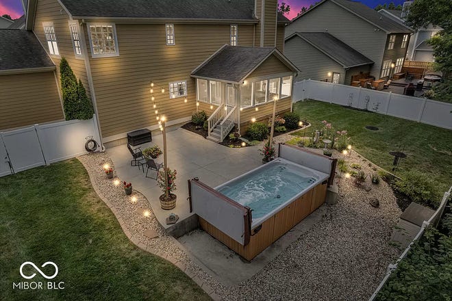 This home in Avon has tons of space inside and a backyard oasis outside with a swim spa and wooded backdrop.