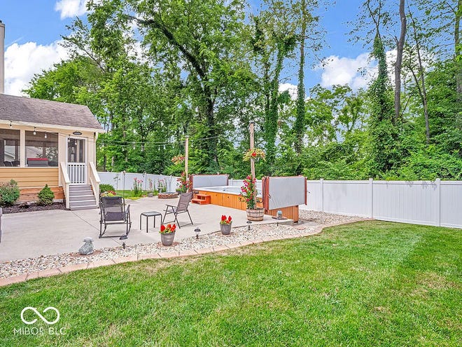 This home in Avon has tons of space inside and a backyard oasis outside with a swim spa and wooded backdrop.