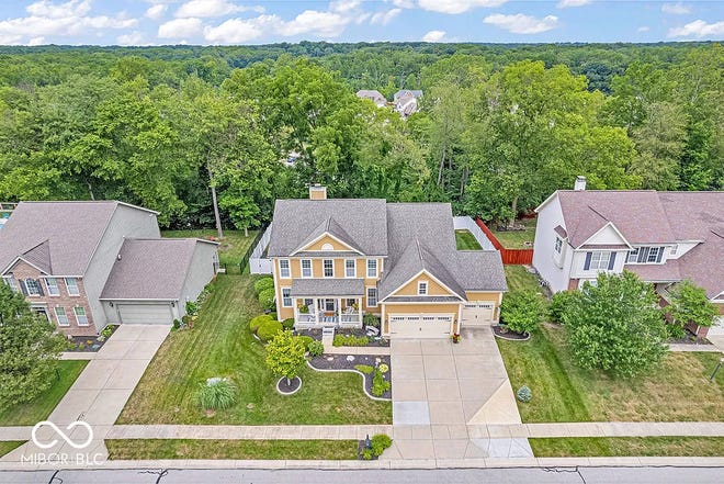 This home in Avon has tons of space inside and a backyard oasis outside with a swim spa and wooded backdrop.