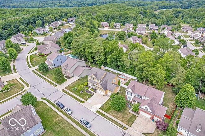 This home in Avon has tons of space inside and a backyard oasis outside with a swim spa and wooded backdrop.