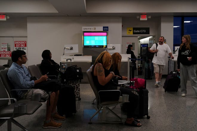 Travelers wait at a gate inside Terminal C in Newark International Airport, after United Airlines and other airlines grounded flights due to a worldwide tech outage caused by an update to Crowdstrike's "Falcon Sensor" software which crashed Microsoft Windows systems, in Newark, New Jersey, U.S., July 19, 2024.