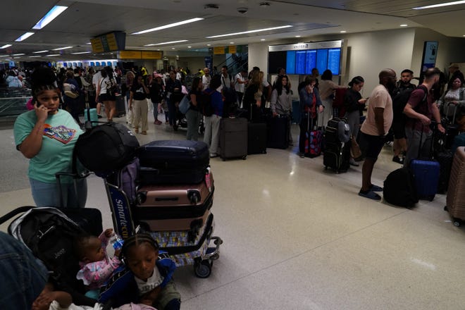 Delayed travelers wait to check in inside Terminal C in Newark International Airport, after United Airlines and other airlines grounded flights due to a worldwide tech outage caused by an update to Crowdstrike's "Falcon Sensor" software which crashed Microsoft Windows systems, in Newark, New Jersey, U.S., July 19, 2024.