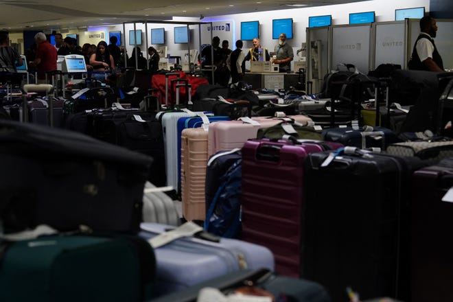 Accumulated luggage is seen as United Airlines employees work to check in travelers inside the departures area of Terminal C in Newark International Airport, after United Airlines and other airlines grounded flights due to a worldwide tech outage caused by an update to Crowdstrike's "Falcon Sensor" software which crashed Microsoft Windows systems, in Newark, New Jersey, U.S., July 19, 2024.