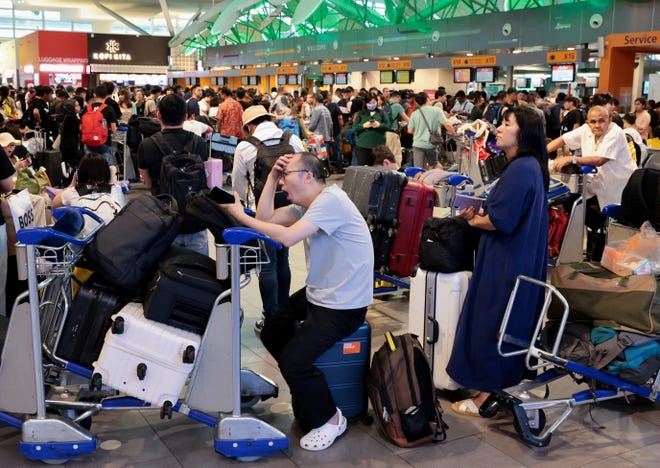 AirAsia passengers wait to be checked in manually at Kuala Lumpur International Airport's Terminal 2, after a global IT system outage, in Sepang, Malaysia, July 19, 2024.