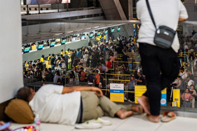 Passengers queue at airline counters at the Ninoy Aquino International Airport, in Pasay City, Metro Manila, Philippines, July 19, 2024. REUTERS/Lisa Marie David