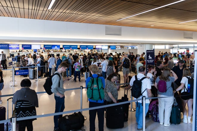 Travelers wait in a Delta Airlines line for information on their delayed or canceled flights on July 19, 2024, at Sky Harbor Airport in Phoenix.