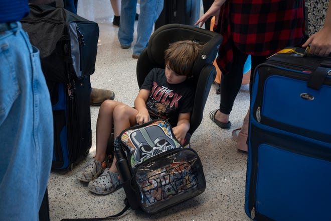 Miles Crumley (6) waits with his family in line at the Delta Air Lines ticket counter in Terminal 3, July 19, 2024, at Phoenix Sky Harbor International Airport.